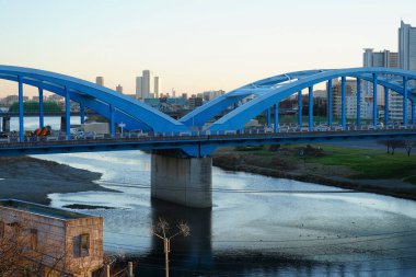 Akşamları nehir boyunca uzanan mavi kemerli köprü