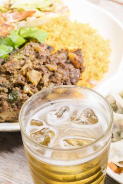 Bir tabak lezzetli yemek, pirinç ve sığır eti, bir bardak bira, yakın çekim. 