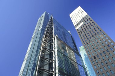 Güneşli bir günde modern şehir mimarisi. Gökdelenlerin mavi gökyüzüne bakışı
