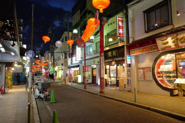Modern Japon şehrinin caddesindeki aydınlık dükkanlar 
