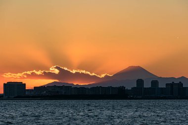 Denizin üzerinde güzel bir gün batımı, ufukta Fuji dağı, Japonya 