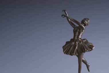 Gri arka planda güzel bir balerinin metal heykeli