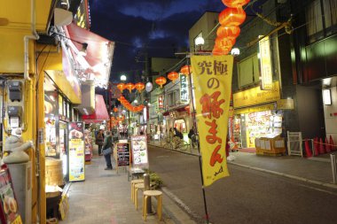 Modern Japon şehrinin caddesindeki aydınlık dükkanlar 