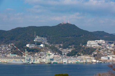 Güneşli bir günde deniz manzarası ve yeşil dağlar 
