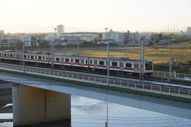 Japonya 'da nehir köprüsü boyunca tren. 