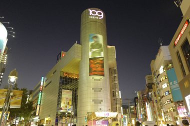 Tokyo City 'deki alışveriş merkezi binası ile aydınlatılmış cadde, Japonya