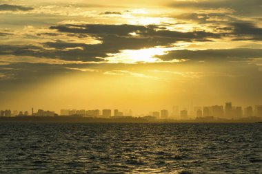 Şehir manzarası gökyüzü ve deniz üzerinde gün batımı
