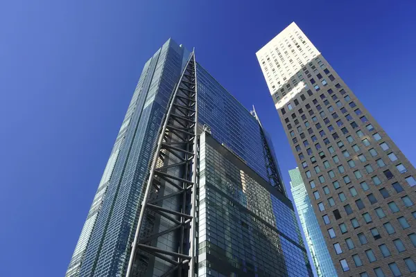 Güneşli bir günde modern şehir mimarisi. Gökdelenlerin mavi gökyüzüne bakışı