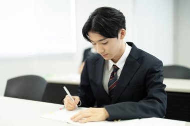 Japon erkek öğrenci sınıfta öğrenim görüyor