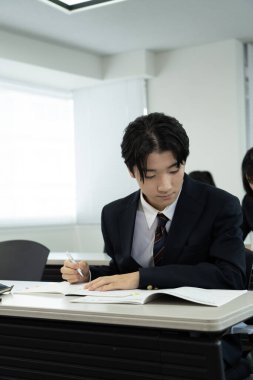 Japon erkek öğrenci sınıfta öğrenim görüyor