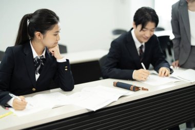 Sınıfta çalışan üniformalı Japon öğrenciler.