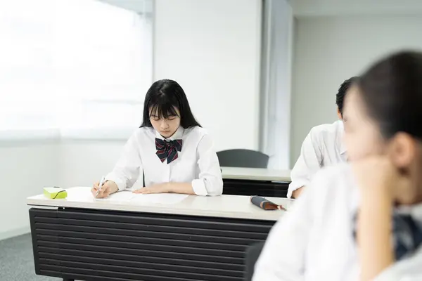 教室で勉強する制服の日本人学生 — ストック写真