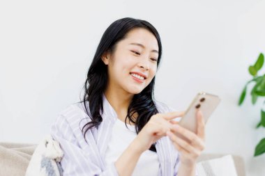 Genç Asyalı kadın akıllı telefon kullanıyor. Yaşam tarzı insan kavramı