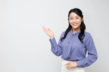 Güzel Asyalı genç bir kadının portresi. Elle fotokopi alanını gösteriyor. 