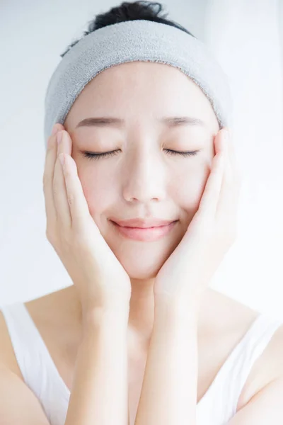 Beautiful Asian woman touching face. Skincare concept