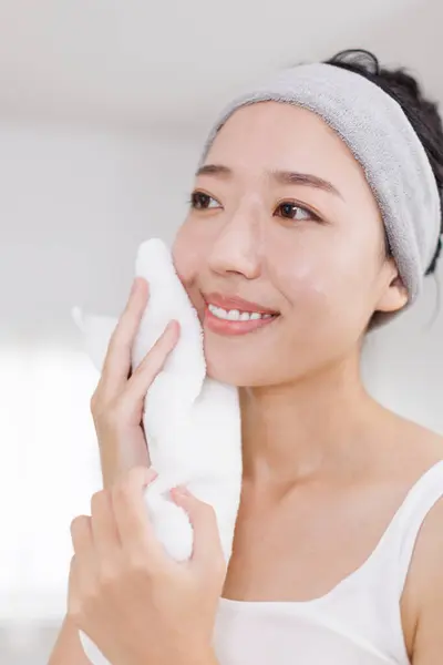 beautiful Japanese woman wiping face with towel