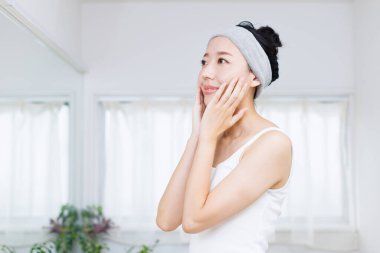 Güzel Japon kadın yüzüne dokunuyor. Güzellik ve sağlık hizmeti kavramı