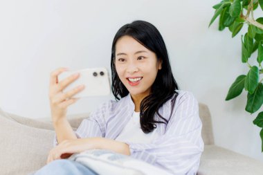 Genç Asyalı kadın akıllı telefon kullanıyor. Yaşam tarzı insan kavramı