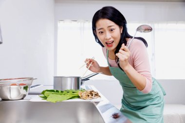 Korkmuş Japon kadın mutfaktaki böceğe bakıyor.