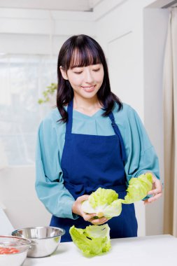 Elinde yeşil lahana tutan güzel bir Japon kadın.