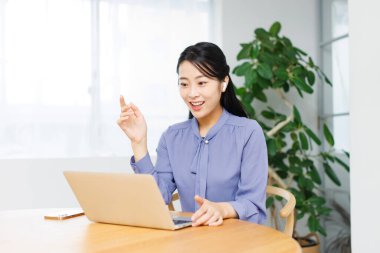 Asyalı iş kadınının görüntülü arama yaparken bir fikri var.