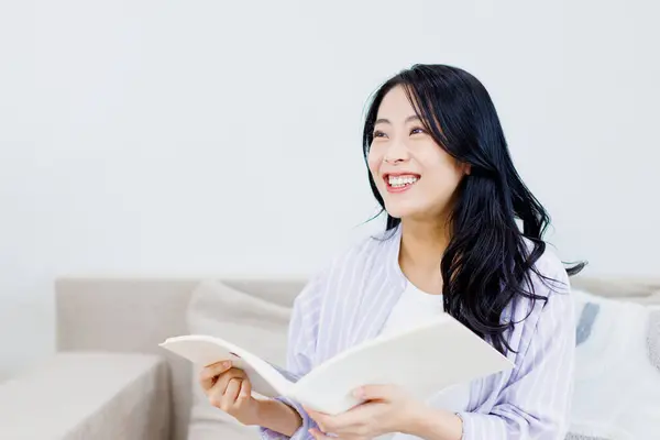 Mooie Aziatische Vrouw Zitten Met Tijdschrift Bank Thuis — Stockfoto