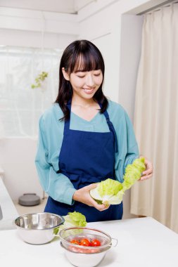 Elinde yeşil lahana tutan güzel bir Japon kadın.