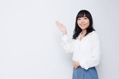 Stüdyo arka planında boş alanı olan genç Asyalı kadın.