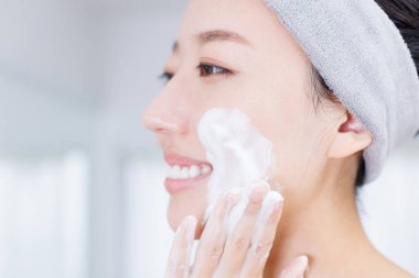 Cilt bakımı yapan Asyalı güzel bir kadının portresi.