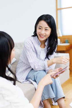 Asyalı kadınlar evde akıllı telefon kullanıyorlar. 