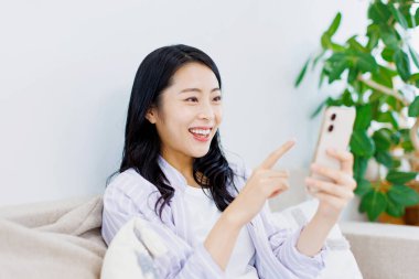 Genç Asyalı kadın akıllı telefon kullanıyor. Yaşam tarzı insan kavramı