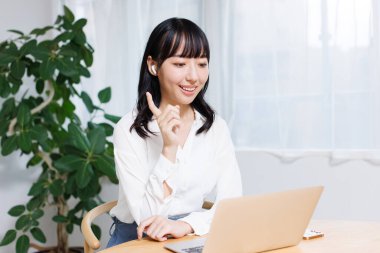 Asyalı iş kadınının görüntülü arama yaparken bir fikri var.