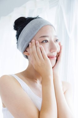 Güzel Japon kadın yüzüne dokunuyor. Güzellik ve sağlık hizmeti kavramı