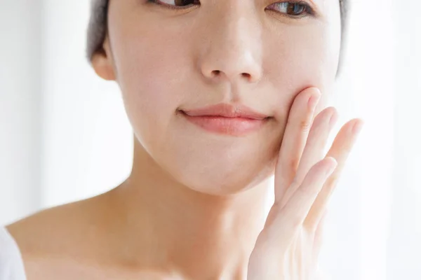 beautiful Japanese woman touching face. Beauty and healthcare concept