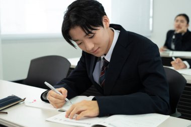 Modern sınıfta okuyan yakışıklı Japon okul çocuğunun portresi.  