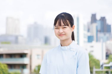 Dışarıda poz veren Asyalı kadın doktorun portresi.