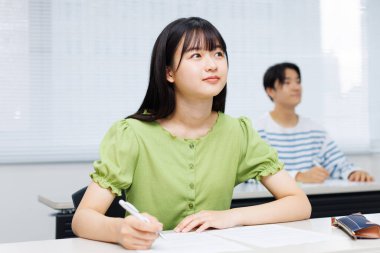 Sınıfta not alan genç bir kız öğrencinin portresi. 