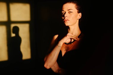 Su sıçraması. Suyun altında siyah elbiseli bir kız. Islak giysiler. Rahatlamanın tadını çıkaran genç bir kadın. Siyah fotoğraf