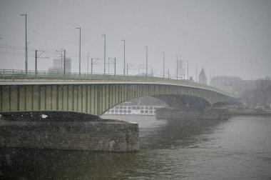 COLOGNE, GERMANY - 4 ARALIK 2023: Rhine Nehri ve Deutz Köprüsü Şehirde kar yağışı sırasında gökyüzüne karşı 