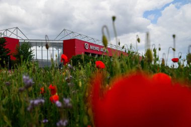 MAINZ, ALMANY - 17 MAYIS, 2025: 1 'in ana stadyumu olan Mewa ArENA' nın genel manzarası. FSV Mainz 05, renkli çiçek tarlalarının arkasında görüldü. Bundesliga eşleşmesi öncesinde manzaralı atmosfer oluşturuluyor.
