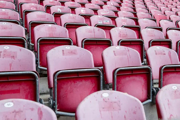 MAINZ, GERMANY - 17 Mayıs 2025: FSV Mainz 05 'in Bundesliga maçından önce MeWA ArENA' daki boş kırmızı stadyum koltuklarının yakın görüntüsü. Bazı çıkartmalar sandalyede görünür..