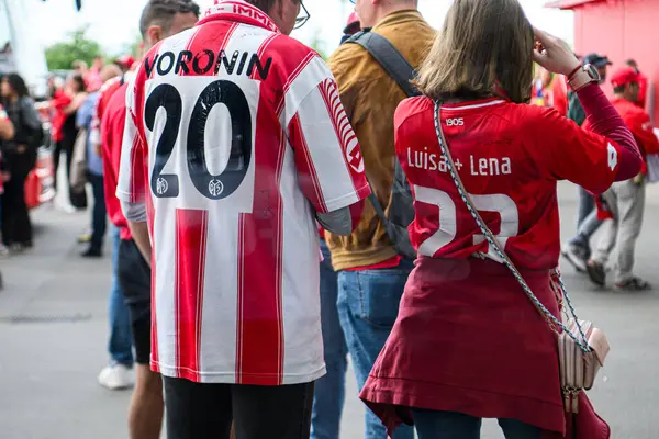 MAINZ, GERMANY - 17 Mayıs 2025: FSV Mainz 05 hayranı Voronin 20 ile retro forma giyer ve MEWA ARENA 'daki Bundesliga maçından önce imza verir. Futbol taraftarları etrafta görülüyor.