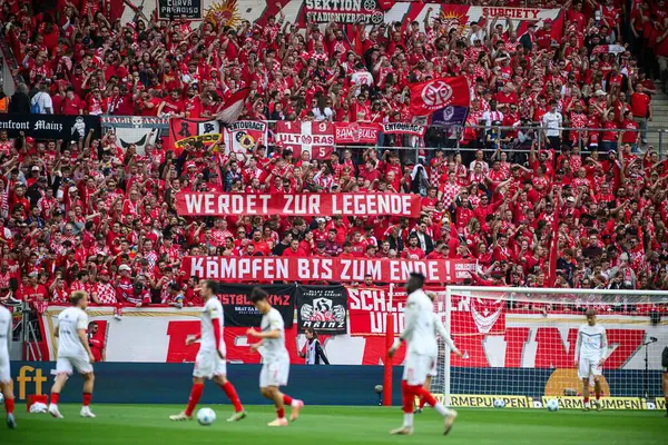 MAINZ, GERMANY - 17 Mayıs 2025: Mainz 05 hayranları WERDET ZUR LEGENDE ve KAMPFEN BIS ZUM yazılı pankartlar sergiliyor. Sahada görülen oyuncular.