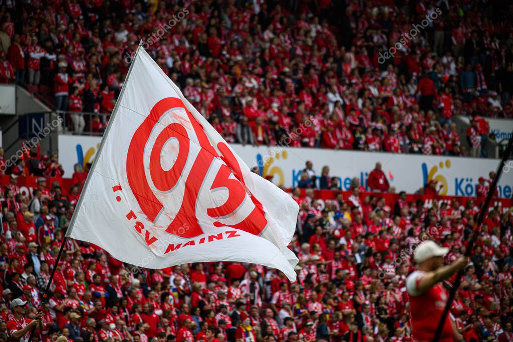 MAINZ, GERMANY - 17 MAY, 2025: A large white flag with the FSV Mainz 05 logo waves among fans during a Bundesliga match at MEWA ARENA.