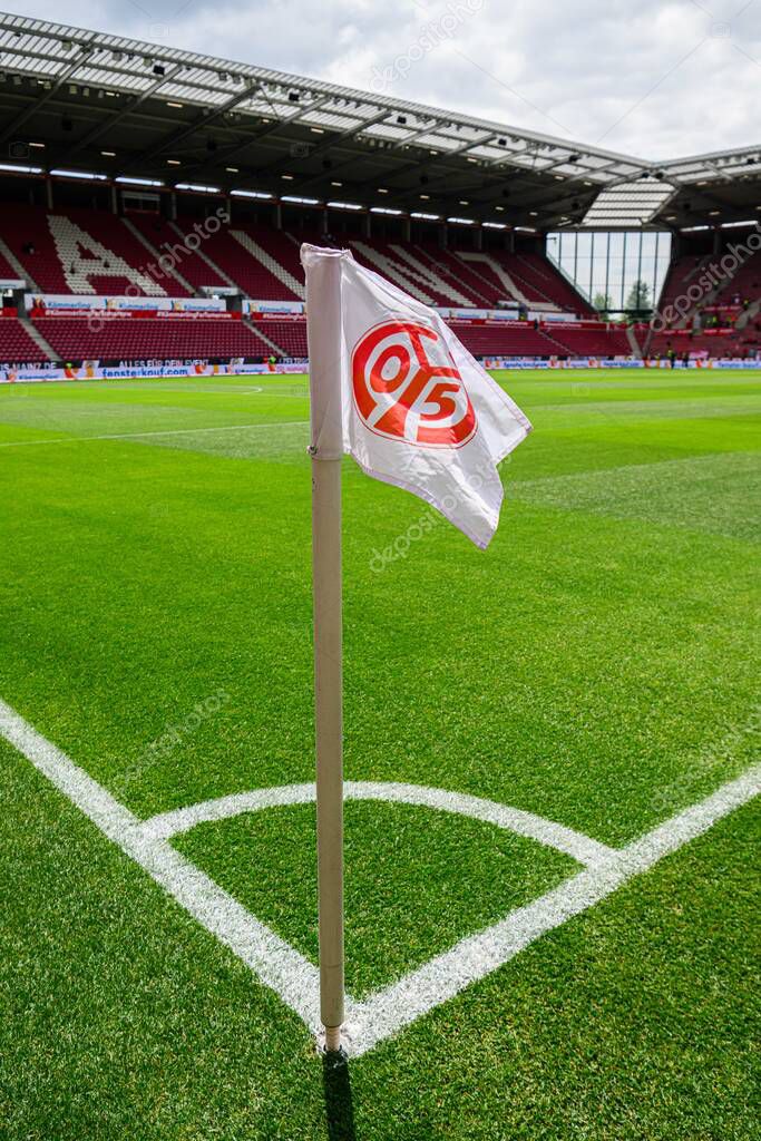 MAINZ, GERMANY - 17 MAY, 2025: Corner flag with FSV Mainz 05 logo stands on pitch at MEWA ARENA before Bundesliga match. Stadium seats and green field visible in background.