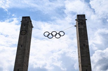 BERLİN, GERMANY - 14 HAZİRAN, 2024: 1936 Olimpiyat Oyunları 'nın ve küresel sporun sembolü olan Berlin' deki Olympiastadion 'daki taş kuleler arasında asılı duran Olimpiyat halkalarının yakın görüntüsü