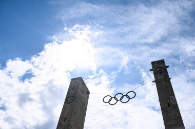 BERLİN, GERMANY - 14 HAZİRAN, 2024: 1936 Olimpiyat Oyunları 'nın ve küresel sporun sembolü olan Berlin' deki Olympiastadion 'daki taş kuleler arasında asılı duran Olimpiyat halkalarının yakın görüntüsü