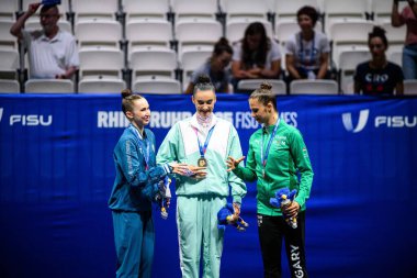 ESSEN, GERMANY - 18 Temmuz 2025: Takhmina IKROMOVA, Alina HARNASKO, Fanni PIGNICZKI - Ritmik jimnastik, Bireysel, Rhine-Ruhr 2025 Messe 'de FISU Dünya Üniversite Oyunları.