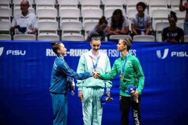 ESSEN, GERMANY - 18 Temmuz 2025: Takhmina IKROMOVA, Alina HARNASKO, Fanni PIGNICZKI - Ritmik jimnastik, Bireysel, Rhine-Ruhr 2025 Messe 'de FISU Dünya Üniversite Oyunları.