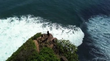 Siyah elbiseli, uçurumun kenarında yalnız bir genç kadın duruyor. Tepeden ateş eden üzgün bir kadın uçurumun kenarında durup okyanusa bakar. Üzüntü ve depresyon kavramı.